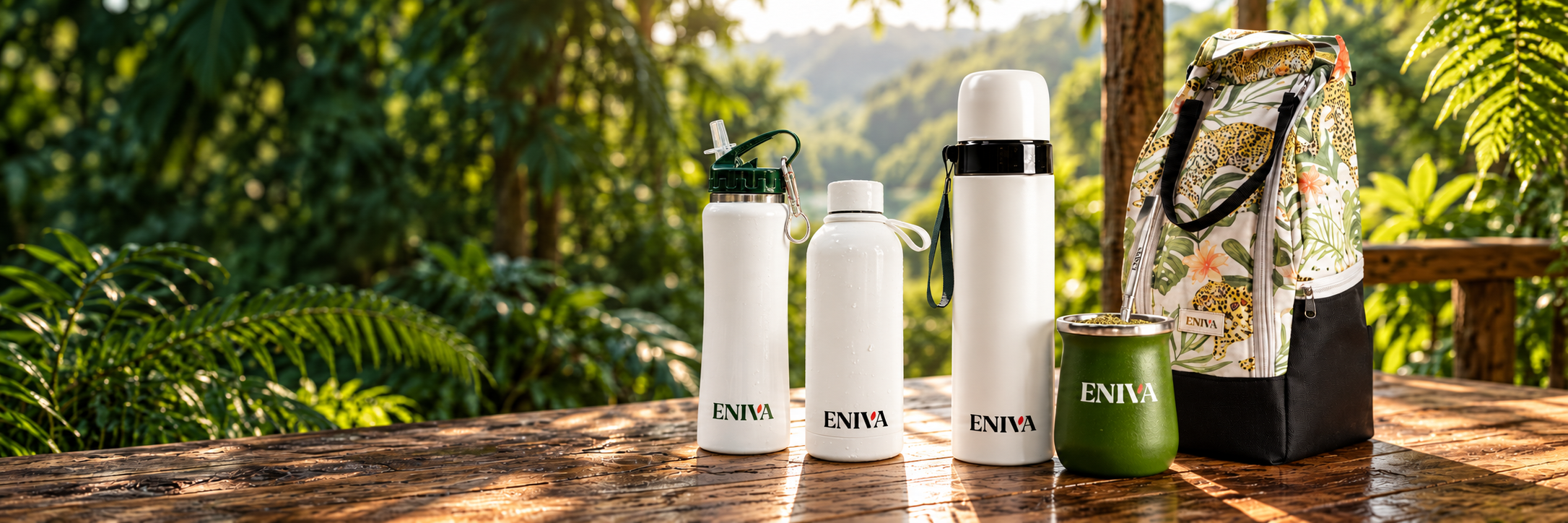 Botellas ENIVA de 500 y 600 ml, termo, mate con bombilla y bolso matero sobre una mesa de madera en la selva misionera